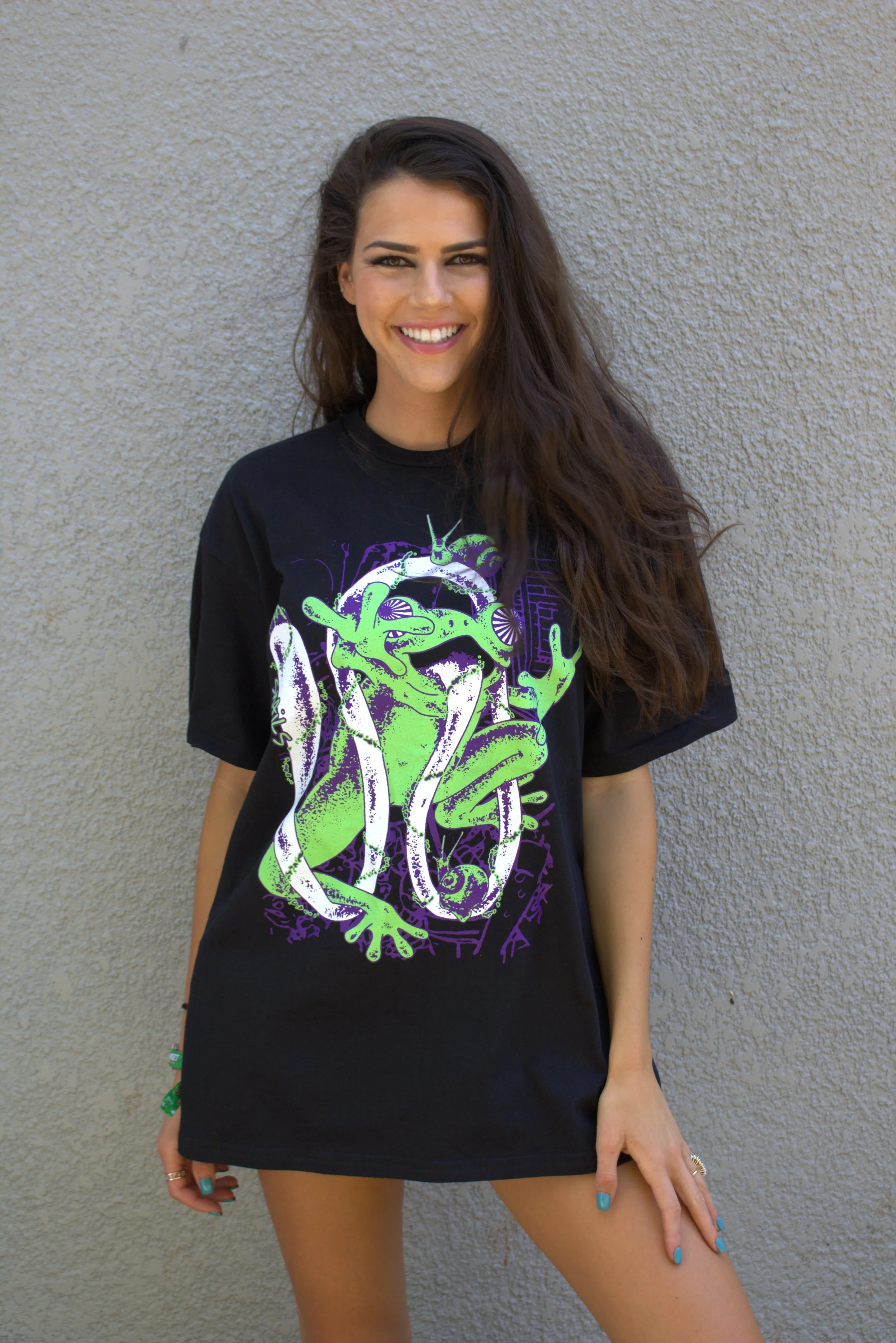 Model wearing a black SNAILS T-shirt with green and purple artwork